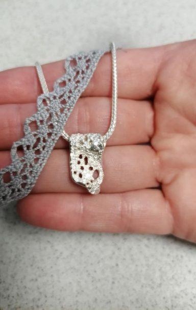 Anhänger aus Spitze gearbeitet.